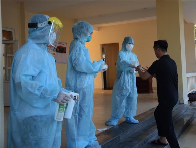 Nhân viên y tế khử trùng tay, phát khẩu trang y tế cho công dân trở về từ Hàn Quốc. Ảnh: Văn Dũng - TTXVN