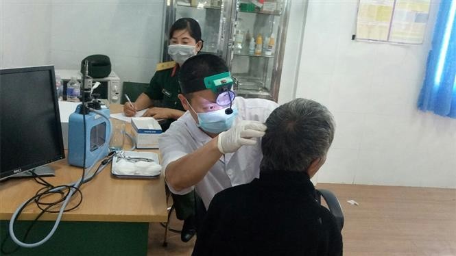Đội ngũ y, bác sỹ của Tổng cục kỹ thuật kết hợp với trạm y tế xã Lơ Pang khám, cấp phát thuốc cho người nghèo, gia đình chính sách xã Lơ Pang, huyện Mang Yang (Gia Lai). Ảnh: Hồng Điệp - TTXVN
