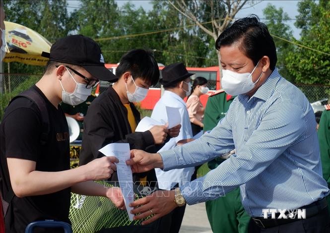 Phó Chủ tịch UBND tỉnh Long An Phạm Tấn Hòa trao giấy xác nhận hoàn thành thời gian cách ly cho các công dân. Ảnh: Đức Hạnh - TTXVN