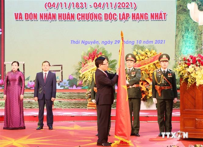 Phó Thủ tướng Thường trực Chính phủ Phạm Bình Minh thực hiện nghi thức trao tặng Huân chương Độc lập hạng Nhất cho Đảng bộ và nhân dân tỉnh Thái Nguyên. Ảnh: Hoàng Nguyên - TTXVN