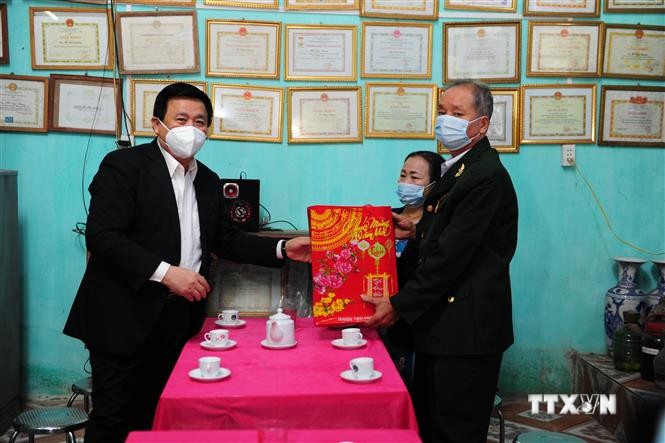 Đồng chí Nguyễn Xuân Thắng, Giám đốc Học viện Chính trị Quốc gia Hồ Chí Minh trao quà cho các hộ gia đình chính sách xã Tân Tiến. Ảnh: Nam Sương - TTXVN