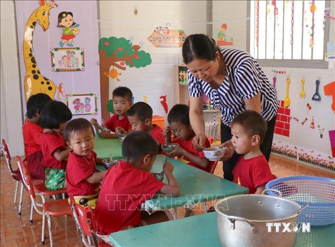 Cô giáo Lê Thị Loan chăm sóc các cháu học sinh trong mỗi bữa ăn hằng ngày. Ảnh: Xuân Tiến - TTXVN