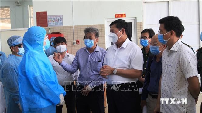 Thứ trưởng Bộ Y tế Đỗ Xuân Tuyên (áo trắng) trao đổi với lực lượng kiểm soát y tế tại Cửa khẩu quốc tế Mộc Bài, huyện Bến Cầu, tỉnh Tây Ninh. Ảnh: Thanh Tân - TTXVN