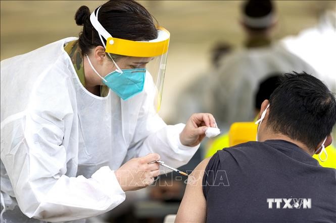 Nhân viên y tế tiêm vaccine ngừa COVID-19 cho người dân tại Sydney, Australia. Ảnh: AFP/TTXVN
