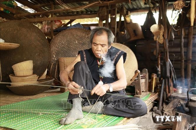 Nghệ nhân Đinh Bi (làng Kgiang, xã Kông Lòng Không, huyện Kbang, tỉnh Gia Lai) dù đã ở tuổi 65 nhưng đôi tay vẫn lanh lợi, đôi mắt sáng trau chuốt từng đường nan. Ảnh: Quang Thái- TTXVN