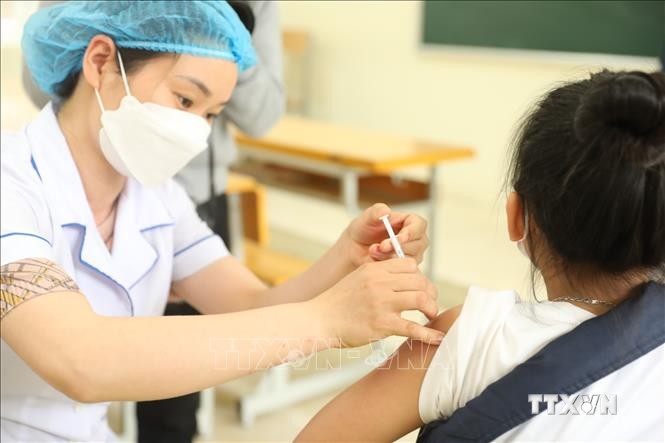 Nhân viên y tế quận Hà Đông tiêm vaccine phòng COVID-19 cho học sinh lớp 6 tại điểm tiêm chủng trường THCS Lê Quý Đôn. Ảnh: Minh Quyết - TTXVN