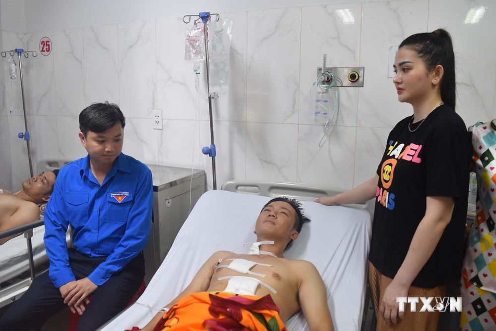 Đồng chí Nguyễn Minh Triết, Bí thư Trung ương Đoàn tới thăm hỏi, động viên chiến sĩ Công an bị thương trong vụ tấn công. Ảnh: Nguyên Dung-TTXVN