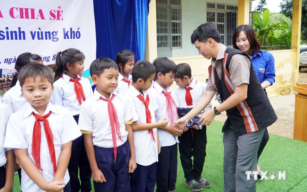 Lãnh đạo huyện Đăk Glei (Kon Tum) trao tặng quần áo đồng phục mới cho các em học sinh có hoàn cảnh khó khăn tại xã Đăk Nhoong. Ảnh: Khoa Chương - TTXVN