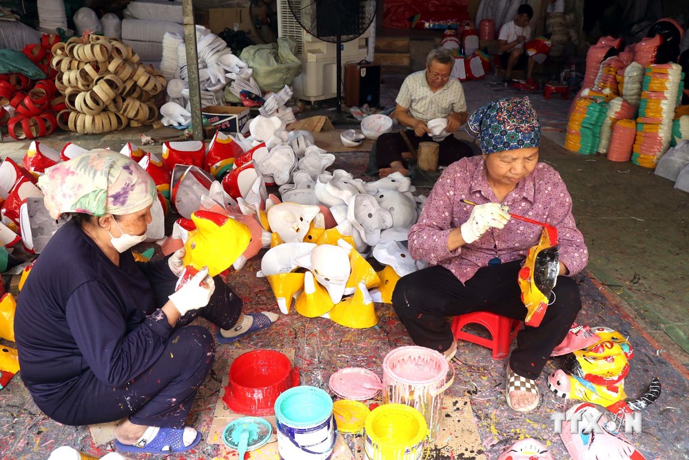 Những người thợ ở thôn ông Hảo, xã Liêu Xá, huyện Yên Mỹ, tỉnh Hưng Yên giữ gìn nghề sản xuất mặt nạ giấy bồi. Ảnh: Mai Ngoan-TTXVN