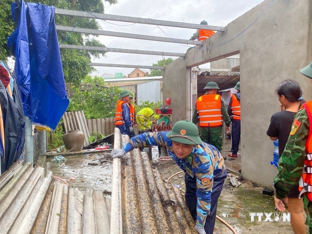 Bộ đội Biên phòng tỉnh Thừa Thiên - Huế phối hợp với chính quyền địa phương hỗ trợ các gia đình bị thiệt hại lợp lại, gia cố mái nhà. Ảnh: TTXVN phát