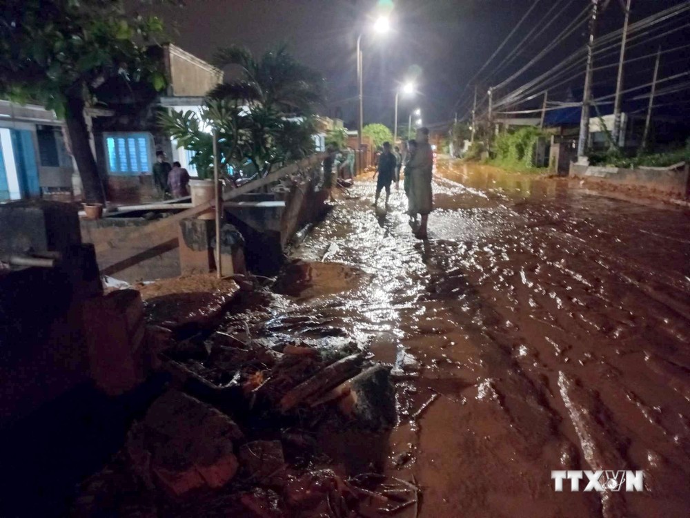 Một phần tuyến đường Lạc Long Quân thuộc xã Tiến Thành, thành phố Phan Thiết bị cát đỏ tràn xuống gây ngập đường. Ảnh: Nguyễn Thanh - TTXVN