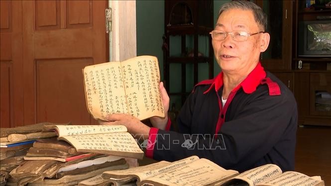 Ông Phùng Quang Du lưu giữ hàng trăm loại sách, tư liệu quý bằng chữ Dao có tuổi đời hàng chục, hàng trăm năm. Ảnh: Hoa Mai - TTXVN