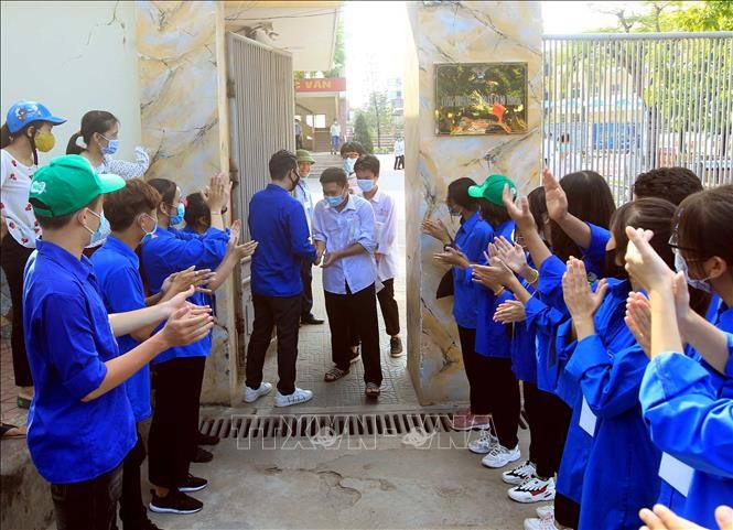 Sinh viên tình nguyện chào mừng thí sinh đầu tiên hoàn thành môn Ngoại ngữ tại điểm thi trường THPT Hồng Bàng, thành phố Hải Phòng. Ảnh: An Đăng - TTXVN