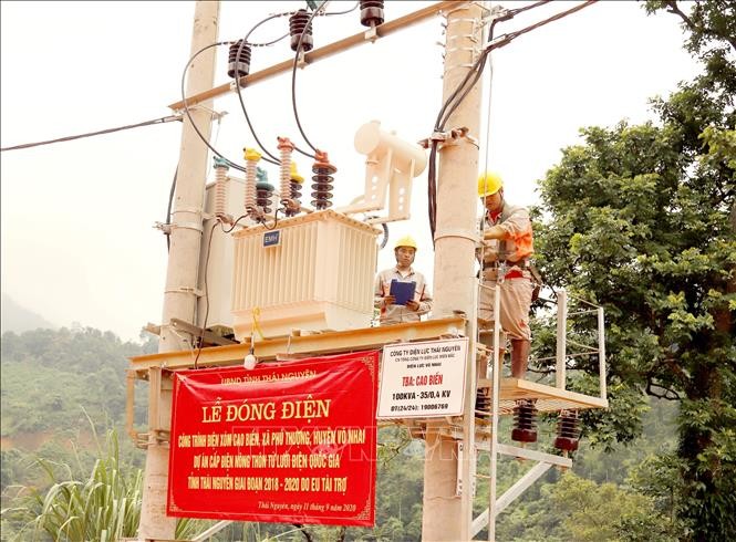 Cán bộ kỹ thuật của điện lực Thái Nguyên đóng điện cho công trình điện xóm Cao Biền. Ảnh: Hoàng Nguyên - TTXVN