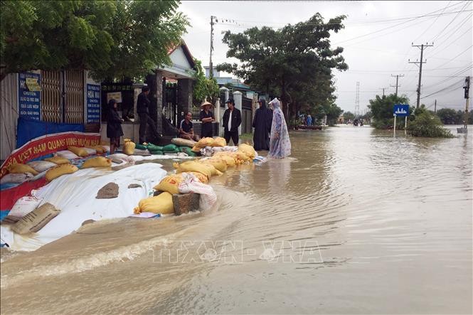 Người dân xã Phước Nam, huyện Thuận Nam (tỉnh Ninh Thuận) dùng bao cát chắn, không cho nước lũ tràn vào nhà. 