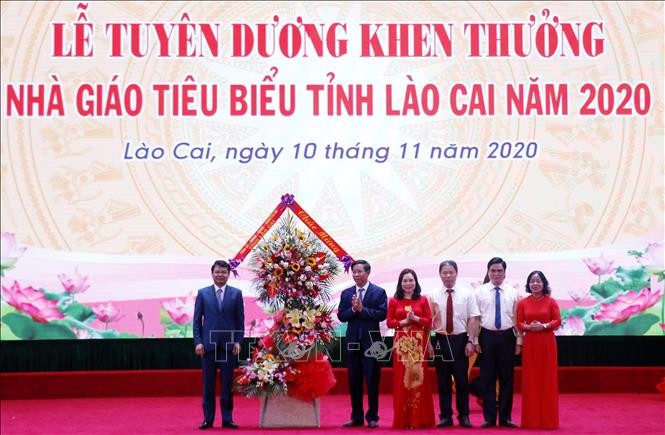 Bí thư tỉnh ủy Lào Cai Đặng Xuân Phong tặng lẵng hoa chúc mừng các thầy cô giáo tại lễ tuyên dương, khen thưởng. Ảnh: Quốc Khánh - TTXVN