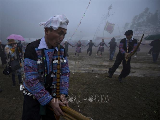 Mặc thời tiết mưa lạnh, những nhạc công hết mình tạo ra những giai điệu truyền thống trong điệu múa tập thể của đồng bào Mông. Ảnh: Trọng Đạt-TTXVN
