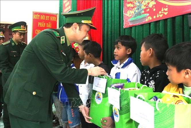 Cán bộ Bộ Tư lệnh Bộ đội Biên phòng tặng quà học sinh "Con nuôi Đồn Biên phòng" tại khu vực biên giới Quảng Bình. Ảnh: Võ Dung -TTXVN