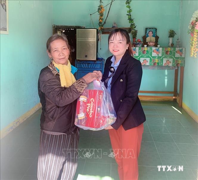 Bí thư Đảng ủy Khánh Trung Cao Thị Ngọc Thanh trao tặng quà tết cho các hộ gia đình chính sách. Ảnh: Phan Sáu - TTXVN