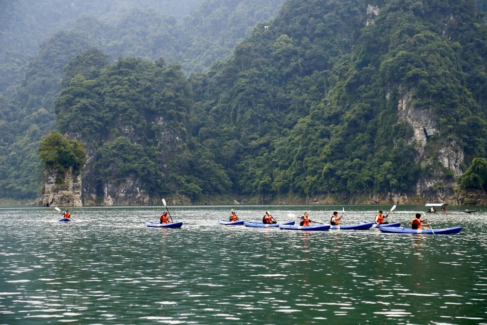 Du khách chèo thuyền kayak khám phá lòng hồ thủy điện Lâm Bình. Ảnh: Nam Sương - TTXVN