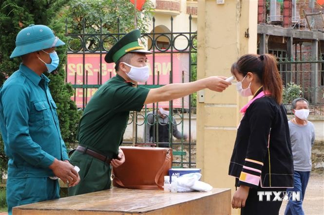 Lực lượng biên phòng Lai Châu phối hợp với lực lượng dân quân địa phương thực hiện nghiêm các biện pháp phòng chống dịch khi đi tuyên truyền bà con nhân dân. Ảnh: Đinh Thùy-TTXVN
