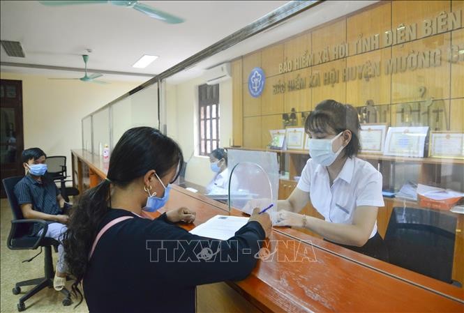 Cán bộ Bảo hiểm xã hội huyện Mường Chà hướng dẫn người dân kê khai đăng ký ứng dụng VssID. Ảnh: Xuân Tư – TTXVN