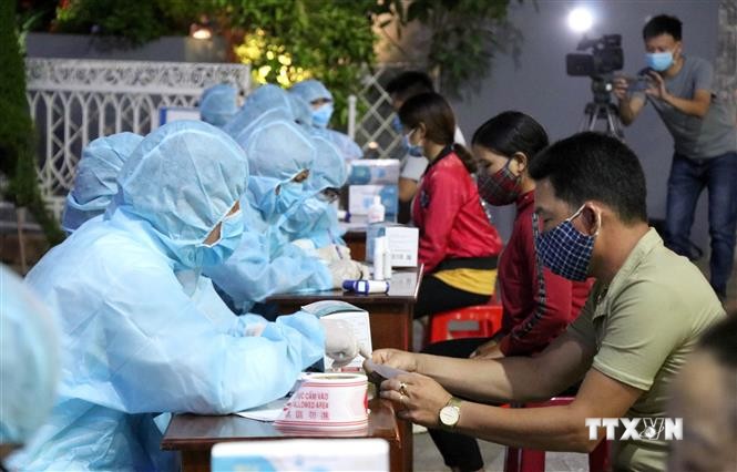 Lực lượng chức năng tổ chức lấy mẫu xét nghiệm sàng lọc SARS-CoV-2 cho tiểu thương chợ đêm Pleiku, Gia Lai. Ảnh: Quang Thái - TTXVN
