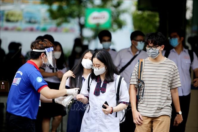 Xịt khử khuẩn cho thí sinh sau khi thi tại điểm thi trường trung học cơ sở Collete (Quận 3, Thành phố Hồ Chí Minh). Ảnh: Thành Chung - TTXVN