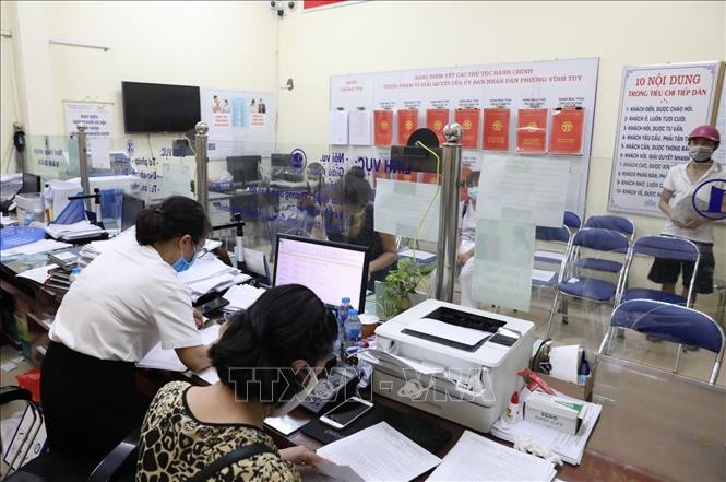 Nhân viên văn phòng tại UBND phường Vĩnh Tuy làm việc hết công suất để kiểm tra, đóng dấu để kịp thời trả giấy cho người dân sớm nhất có thể. Ảnh: Thành Đạt - TTXVN