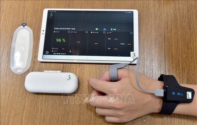Giải pháp công nghệ cao Tele-ICU Monitoring được thực hiện với các thiết bị gồm máy tính bảng, đồng hồ đo mạch và nồng độ oxy trong máu (Checkme O2) và miếng dán đo nhịp tim và nhịp thở (Continuous ECG Recorder). Ảnh: TTXVN phát
