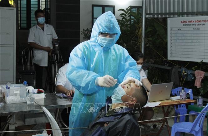 Nhân viên y tế chốt kiểm soát dịch COVID-19 Đu Lau, xã Tân Lang, huyện Phù Yên, tỉnh Sơn La lấy mẫu xét nghiệm cho người dân. Ảnh: TTXVN