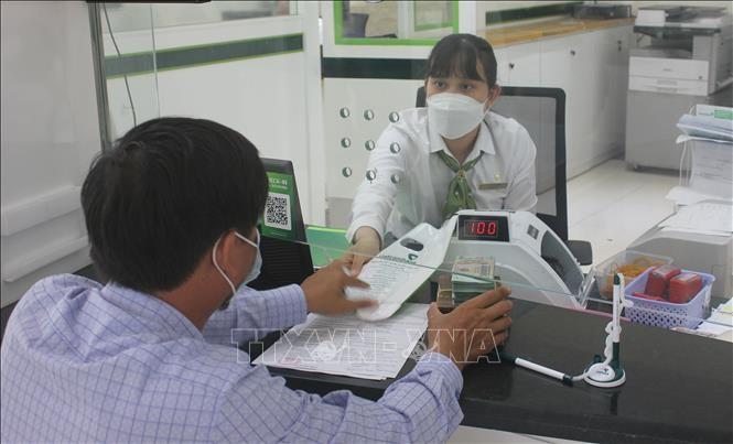 Khách hàng giao dịch tại Ngân hàng TMCP Ngoại thương Việt Nam chi nhánh tỉnh Kon Tum. Ảnh: Dư Toán – TTXVN.