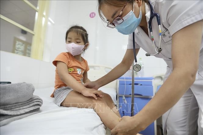  Bác sĩ khám cho bệnh nhi sốt xuất huyết tại bệnh viện Thanh Nhàn. Ảnh: Minh Quyết - TTXVN