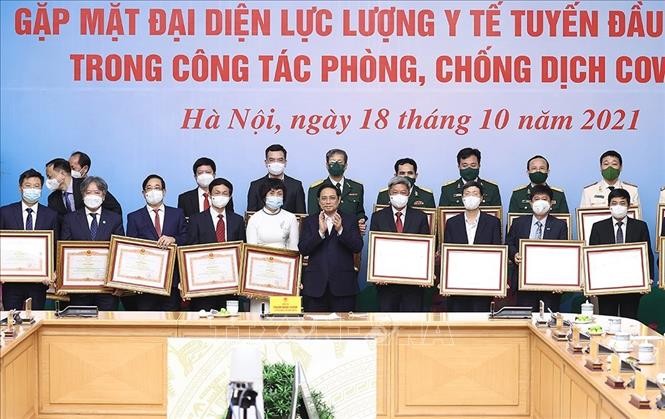 Thủ tướng Phạm Minh Chính trao Bằng khen cho các cá nhân tiêu biểu, xuất sắc trong công tác phòng, chống dịch COVID-19. Ảnh: Dương Giang-TTXVN