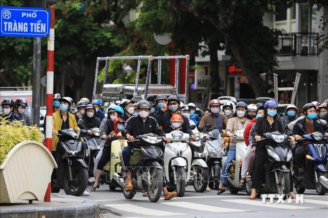 Thành phố Hà Nội đã nới lỏng giãn cách được gần 1 tháng, cuộc sống của người dân đã dần ổn định trở lại bình thường. Trong ảnh: Những người tham gia giao thông dừng đèn đỏ đều tuân thủ đeo khẩu trang phòng chống dịch vừa là bảo vệ sức khỏe tránh ô nhiễm c