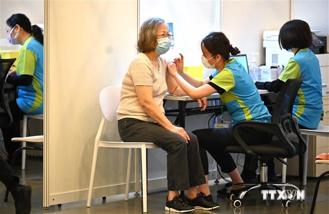 Nhân viên y tế tiêm vaccine ngừa COVID-19 cho người dân tại Hong Kong, Trung Quốc. Ảnh: AFP/TTXVN
