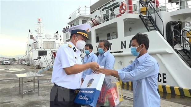 Đại tá Vũ Duy Lưu, Phó Chủ nhiệm Chính trị Vùng 2 Hải quân thăm hỏi, động viên, tặng quà ngư dân. Ảnh: TTXVN phát