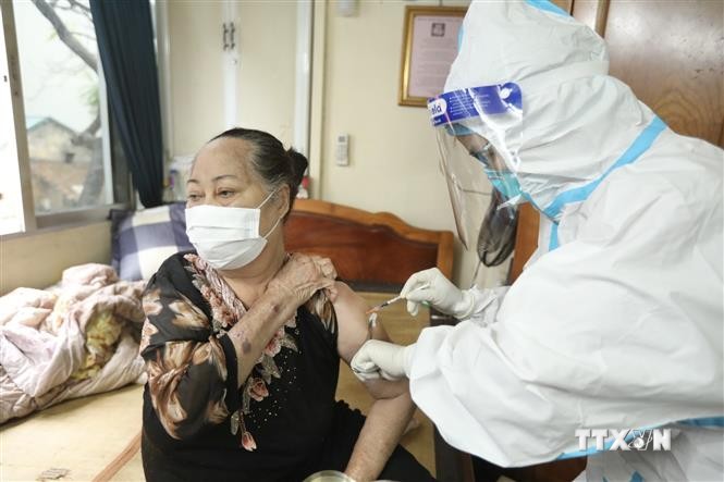 Nhân viên y tế phường Cửa Đông (quận Hoàn Kiếm) tiêm cho người cao tuổi tại nhà. Ảnh: Minh Quyết - TTXVN
