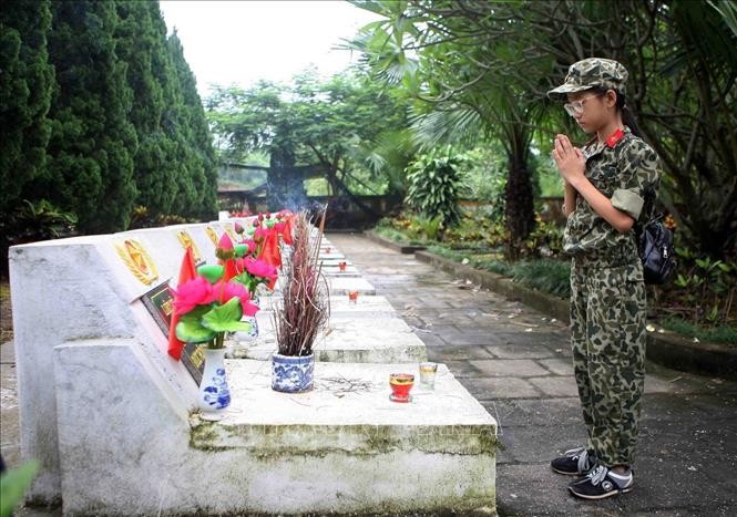 Thế hệ trẻ tưởng nhớ các anh hùng liệt sỹ đã hy sinh bảo vệ Tổ quốc, tại Nghĩa trang liệt sĩ quốc gia Vị Xuyên (Hà Giang). Ảnh: Thanh Tùng-TTXVN