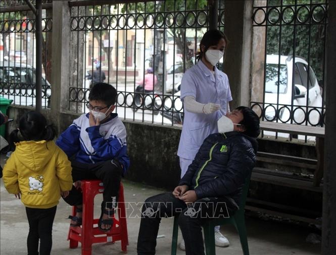Nhân viên y tế lấy mẫu xét nghiệm COVID-19 cho học sinh thành phố Thanh Hóa. Ảnh: Nguyễn Nam-TTXVN