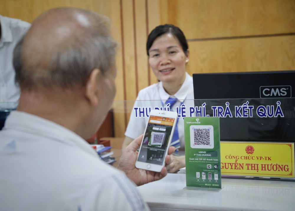 Việc quét mã QR để chuyển khoản nộp lệ phí giúp tiết kiệm thời gian và giảm chi phí tại bộ phận một cửa tại UBND phường Thọ Xương, thành phố Bắc Giang. Ảnh: Danh Lam-TTXVN