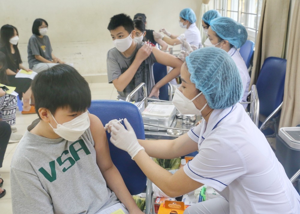 Nhân viên y tế phường Minh Khai tiêm mũi vaccine nhắc lại cho học sinh trường THCS Hà Huy Tập. Ảnh: Tuấn Đức - TTXVN