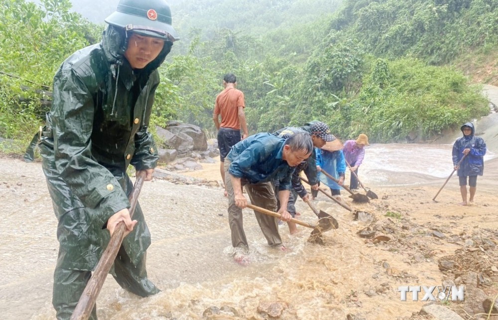 Cán bộ chiến sỹ Đồn Biên phòng Ra Mai, Bộ đội Biên phòng Quảng Bình hỗ trợ cùng nhân dân trên địa bàn khắc phục sạt lở đất đá, khơi thông các tuyến đường trọng yếu. Ảnh: TTXVN phát