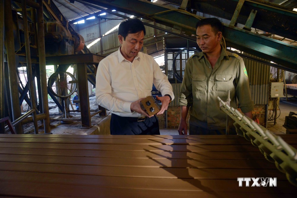 Cựu chiến binh Nguyễn Huy Bẩy (bên trái), Giám đốc Công ty TNHH Sơn Hưng Trung, thành phố Sơn La, kiểm tra sản phẩm. Công ty đã tạo việc làm thường xuyên cho trên 120 cán bộ, công nhân viên, lao động với thu nhập 6 đến 8 triệu đồng/người/tháng. Ảnh: Quang