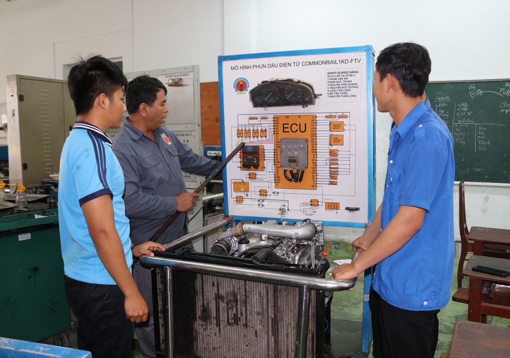Giảng viên Trường Cao đẳng nghề Ninh Thuận hướng dẫn sinh viên học thực hành sửa chữa mô hình động cơ ô tô tại xưởng. Ảnh: Nguyễn Thành – TTXVN