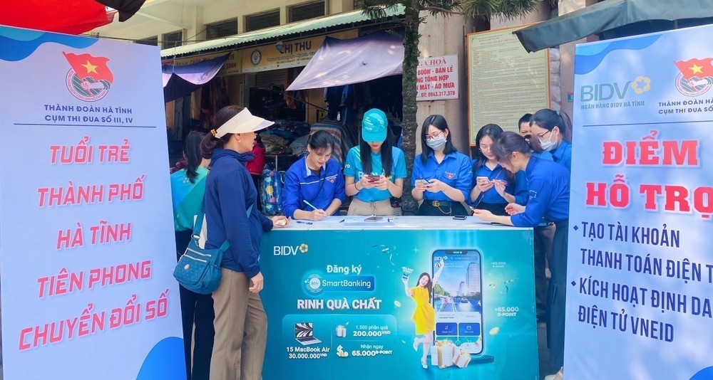 Tuổi trẻ thành phố Hà Tĩnh tổ chức ra mắt mô hình "Chợ thanh toán không dùng tiền mặt" tại chợ Hà Tĩnh, hướng dẫn người dân mở tài khoản thanh toán trực tuyến tại chợ. Ảnh: TTXVN phát