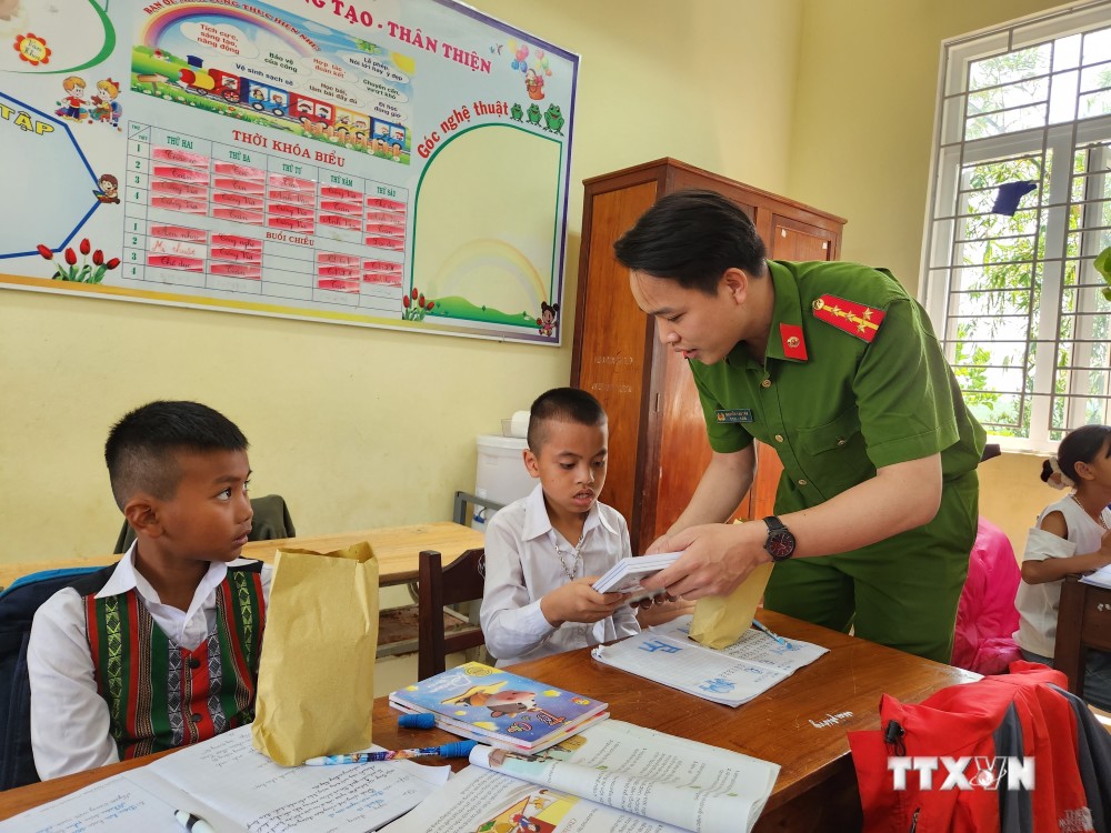 Đối với nhiều em nhỏ xã Quảng Nhâm, Đại uý Tân như một người “anh nuôi” luôn quan tâm, giúp đỡ các em tận tình. Ảnh: Mai Trang-TTXVN