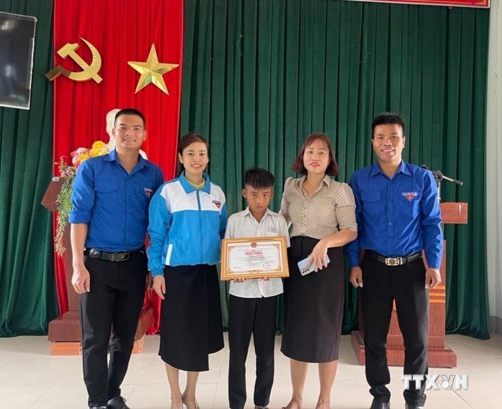 Huyện đoàn Ia Pa tặng Giấy khen cho em Kpă Nguyên vì đã có hành động dũng cảm cứu người bị đuối nước. Ảnh: Quang Thái- TTXVN