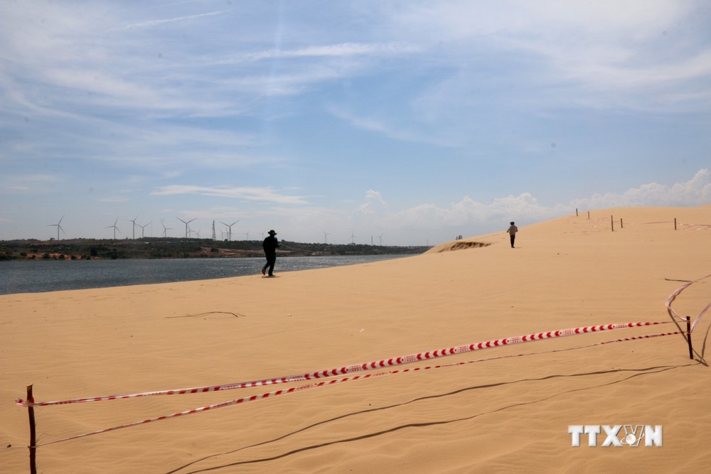 Lực lượng chức năng tiến hành đo hiện trạng khu vực sạt lở thuộc Khu du lịch Bàu Trắng. Ảnh: Nguyễn Thanh - TTXVN