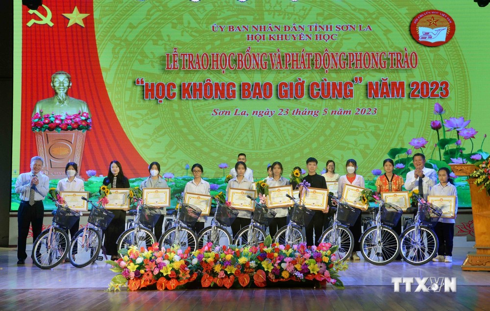 Ban Tổ chức trao Giấy khen của Hội Khuyến học tỉnh Sơn La và xe đạp cho các em học sinh. Ảnh: Quang Quyết - TTXVN